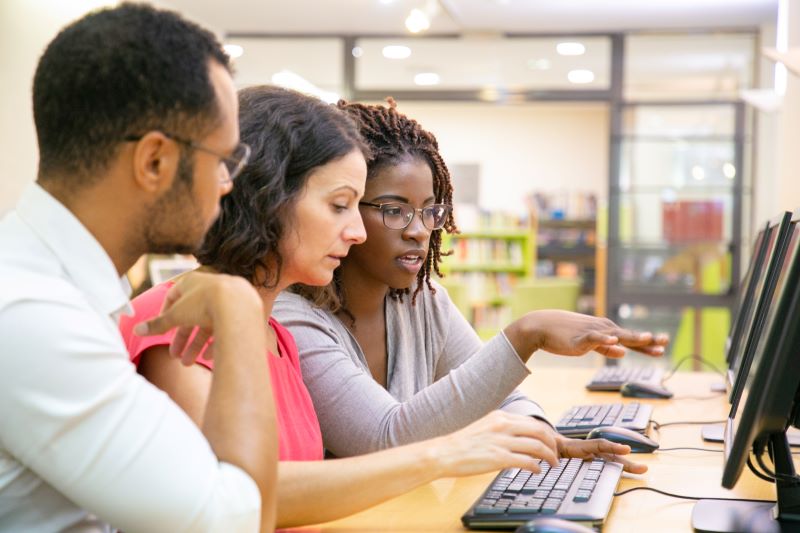 Three employees sitting in office conducting employee onboarding program