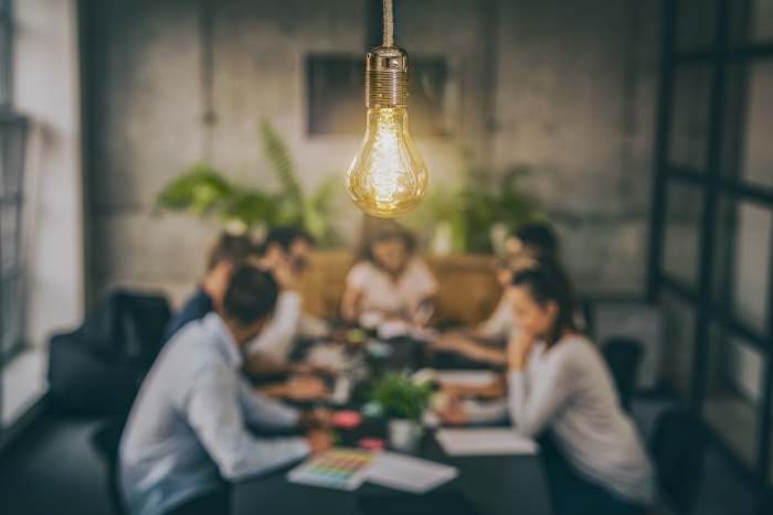 People in a room discussing marketing with a highlighted light bulb in the forefront